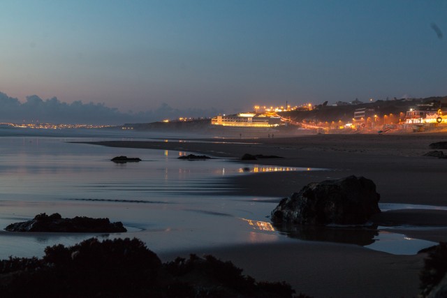 Lõuna-Portugali öine rand ja taamal tuledes mereäärne linn
